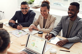 A diverse team of professionals having a meeting in a modern office setting, discussing business strategies. HD wallpaper