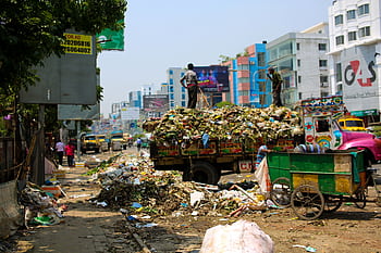 Trash-filled streets with vibrant urban buildings in Bangladesh. HD wallpaper