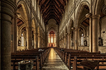 A beautifully detailed interior of a gothic-style historic cathedral with arches and pews. HD wallpaper