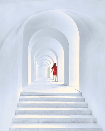 A woman in a red dress walks through a series of white arches, creating a stunning contrast and leading lines. HD phone wallpaper