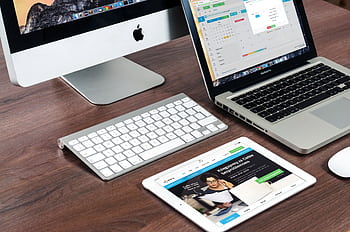 A sleek office desk setup featuring Apple devices: iMac, MacBook, and iPad. HD wallpaper
