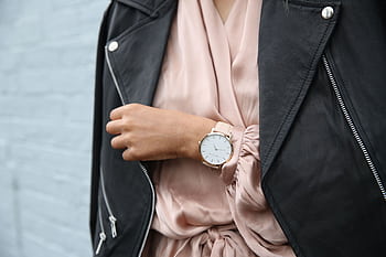 Stylish woman in a leather jacket showcasing an elegant wristwatch, perfect for fashion-forward individuals. HD wallpaper