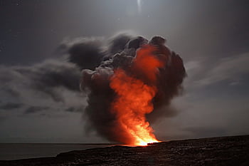 Volcanic eruption with smoke and lava under a starry night sky. HD wallpaper