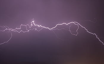 A vivid display of lightning bolts illuminating the night sky, capturing the electric power of a thunderstorm. HD wallpaper