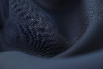 Detailed close-up of woven blue fabric with elegant crumples, highlighting texture and depth. HD wallpaper