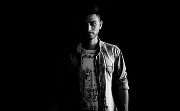Black and white portrait of a man in a denim jacket captured dramatically. HD wallpaper