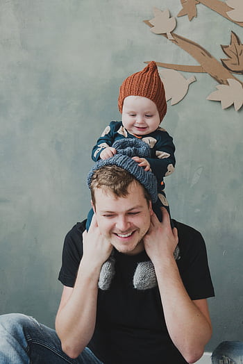 Heartwarming portrait of a father and son indoors, sharing a playful moment together. HD phone wallpaper