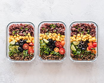 Colorful healthy meal prep with corn, olives, tomatoes, and lentils in glass containers. Perfect for mindful eating. HD wallpaper