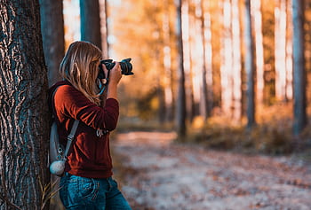 A woman taking in an autumn forest, perfectly capturing the beauty of nature. HD wallpaper