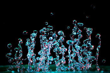 A striking close-up of vibrant water droplets capturing motion and abstract beauty. HD wallpaper