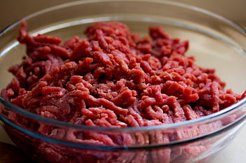 High-quality of fresh ground beef in a glass bowl, ideal for culinary and food-related themes. HD wallpaper