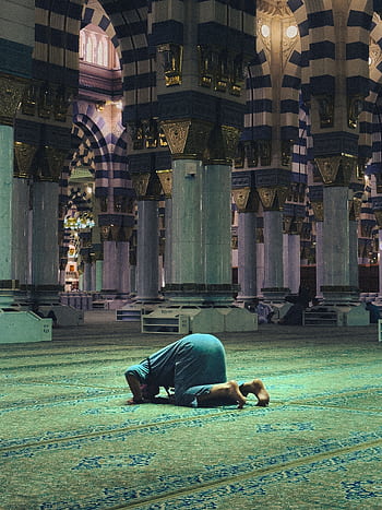 A person praying inside the historic Al-Masjid an-Nabawi, Medina, Saudi Arabia. HD phone wallpaper