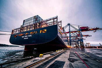 A large cargo ship docked at Gothenburg port with industrial cranes, Sweden. HD wallpaper