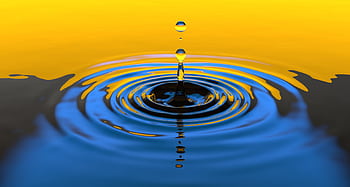 Close-up macro shot of a water droplet creating ripples with vibrant colors. HD wallpaper