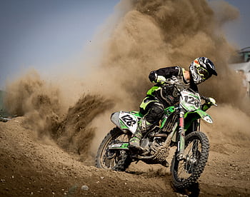 A thrilling motocross rider powers through dust in Beckov, Slovakia. HD wallpaper