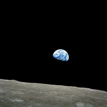 Iconic view of Earth rising over the lunar surface in space, capturing celestial beauty. HD phone wallpaper