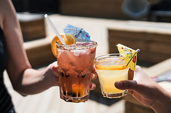 Two refreshing cocktails with citrus and umbrellas, perfect for a summer day outdoors. HD wallpaper