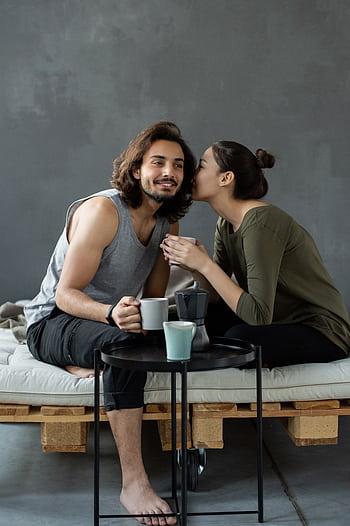 Young couple enjoying a cozy morning with coffee, creating intimate moments indoors. HD phone wallpaper