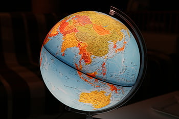 A vibrant illuminated globe showcasing Earth's continents in a dark setting, ideal for educational and decor purposes. HD wallpaper