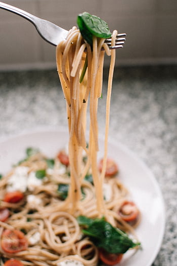 Close-up of freshly cooked spaghetti with cherry tomatoes, spinach, and mozzarella cheese on a plate. HD phone wallpaper