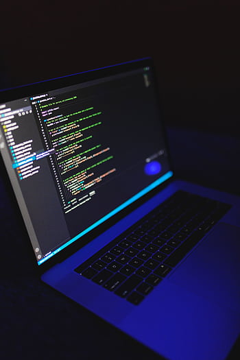 A laptop showcasing colorful code in a dark environment, ideal for tech or programming content. HD phone wallpaper