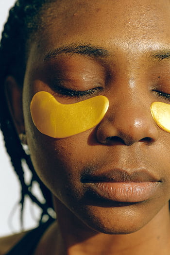 Close-up of a woman with gold eye masks enjoying a skincare routine. HD phone wallpaper