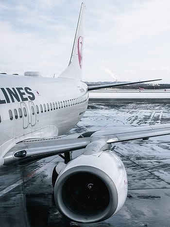 Close-up of an airliner on a wet runway after rain with reflections on the tarmac. HD phone wallpaper
