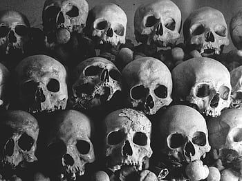 Dark and haunting pile of human skulls creating a creepy atmosphere. HD wallpaper