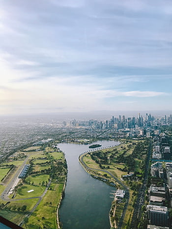 Breathtaking aerial view of Melbourne skyline along the Yarra River with lush greenery. HD phone wallpaper