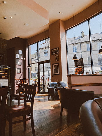 Warm and inviting café interior with wooden flooring and large windows letting in natural daylight. HD phone wallpaper