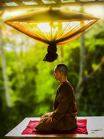A Buddhist monk meditates outdoors, embodying peace and spirituality. HD phone wallpaper