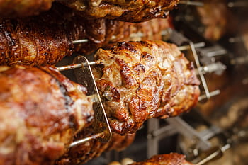 Close-up of juicy and perfectly grilled rotisserie pork, ideal for barbecue lovers. HD wallpaper