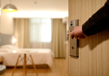 A soft-lit hotel room entrance, welcoming guests with luxury appeal and comfort. HD wallpaper