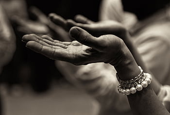 Close-up of expressive hands in prayer wearing a bracelet, conveying faith and devotion. HD wallpaper