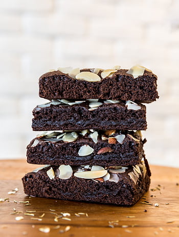 Rich and moist chocolate brownies topped with almond slices, perfect for dessert lovers. HD phone wallpaper