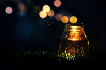 mood jar candle light sequins bokeh grass green background full screen HD wallpaper