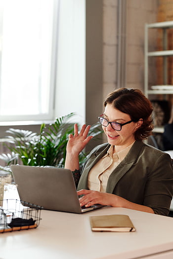 Businesswoman in glasses on a video call in a stylish office setting. HD phone wallpaper
