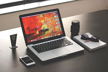 A clean, organized workspace featuring a MacBook, smart, and notebook. HD wallpaper