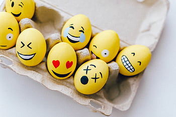 Bright yellow Easter eggs painted with fun emoticon faces in an egg carton. HD wallpaper