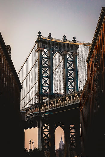 A stunning view of the Brooklyn Bridge at dusk with the Empire State Building in the background. HD phone wallpaper