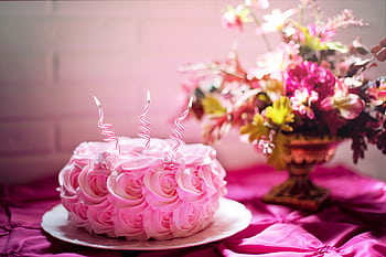 A beautifully decorated pink cake with curly candles and a floral bouquet, perfect for romantic celebrations. HD wallpaper