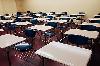 An empty classroom featuring neatly arranged desks and chairs ready for use. HD wallpaper