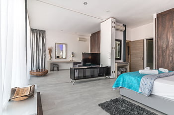 Spacious and modern bedroom with sleek design, featuring elegant decor and natural lighting. HD wallpaper