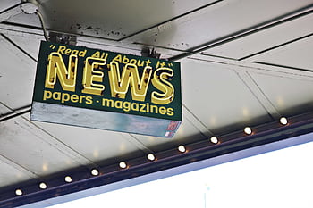 Illuminated neon news sign against ceiling, showcasing urban style and modern design. HD wallpaper