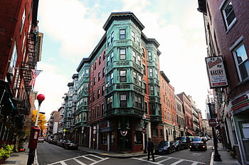 Charming street corner with vintage buildings in a bustling city scene. HD wallpaper