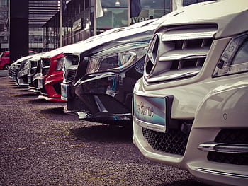 Luxury cars lined up at an outdoor dealership, showcasing sleek designs. HD wallpaper