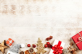 A flatlay of Christmas gifts and ornaments on a rustic wooden background, perfect for holiday themes. HD wallpaper