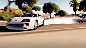 A white sports car drifting on a sunny day with smoke trail on an urban road. HD wallpaper