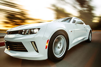 A white sportscar in motion showcasing speed and style on an open road. HD wallpaper