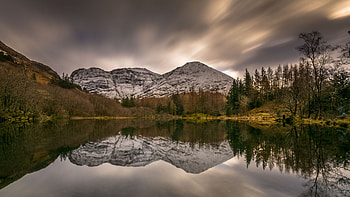 Landscape View Of Rock Mountains Trees Bushes Grass Field Under Black Clouds Sky Reflection On Lake Nature HD wallpaper